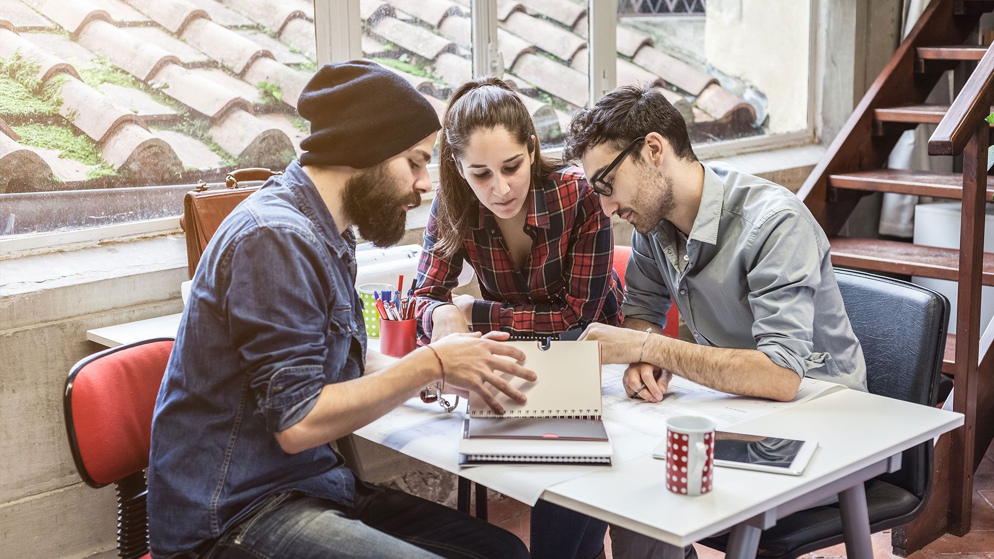 Three people at table studying notes