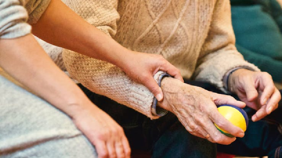 Picture of someone holding an elderly person's hand.