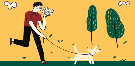 Man walking a dog while reading a book