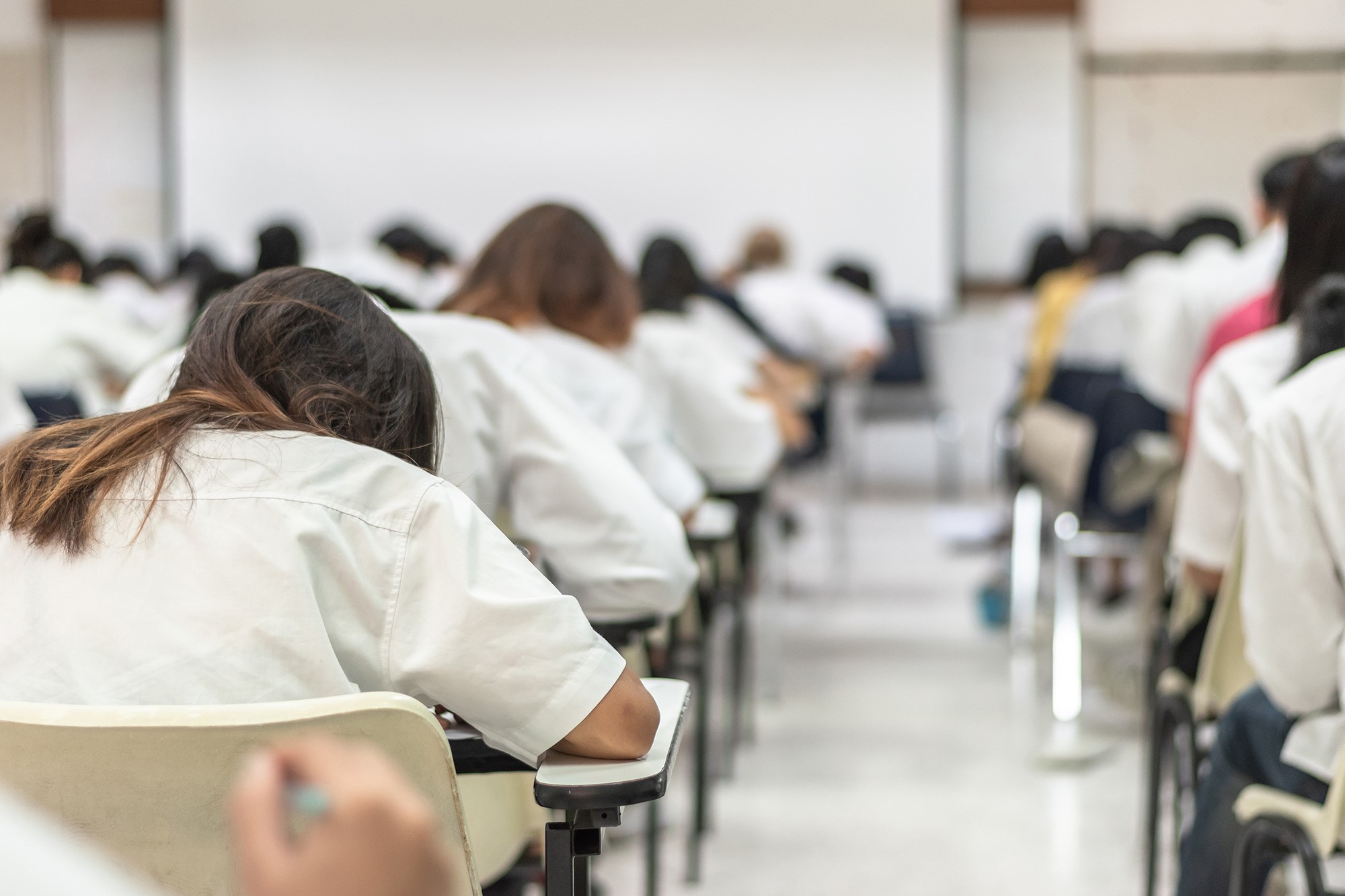 Pupils sitting at desks in an exam hall