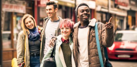 Happy multiracial friends walking on Brick Lane at Shoreditch London.